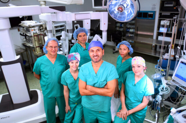 Dr. Awad surrounded by surgical care providers in an operating room