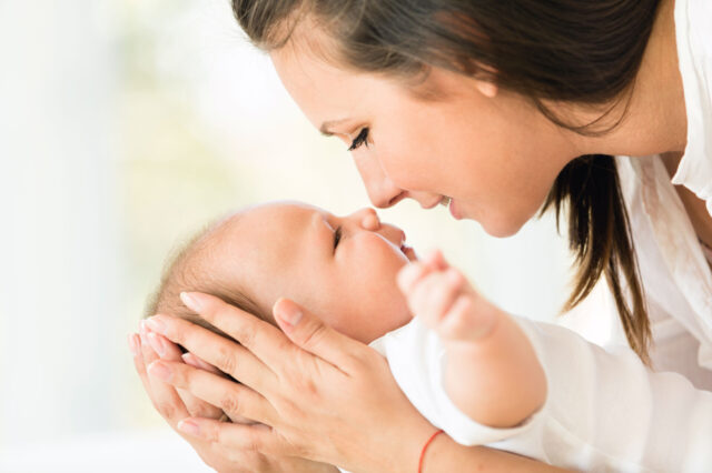 A woman and a baby touching noses