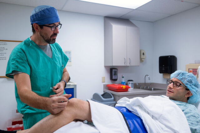 UF Health pain medicine physician examines patient's knee