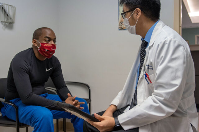 UF Health endocrinologist talks with patient in exam room.
