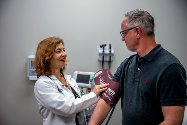 Primary care physician places blood pressure cuff on