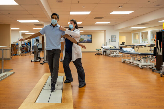 UF Health rehabilitation provider assists patient on balance test