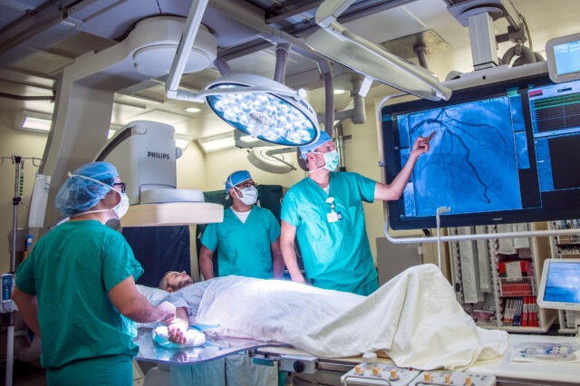 Cardiology staff perform a catheter procedure on a patient