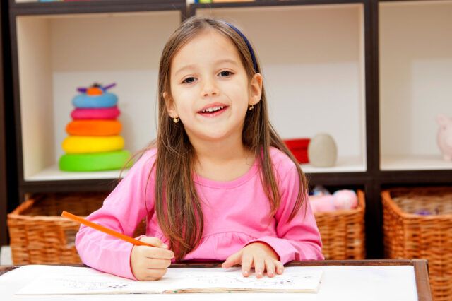 Young girl sitting at desk doing classwork.