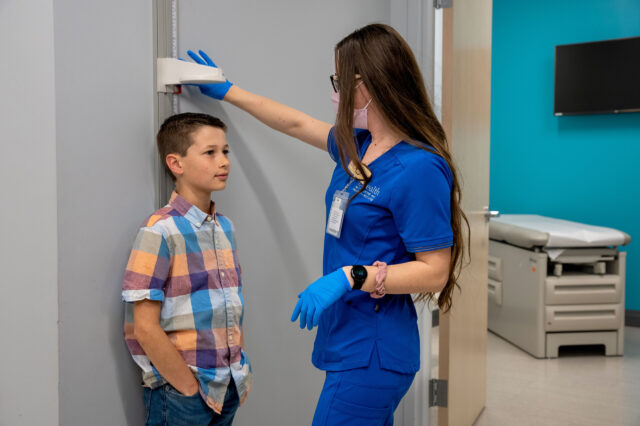 Medical assistant measures the height of a pediatric patient at UF Health Family Medicine and Pediatrics - Nocatee