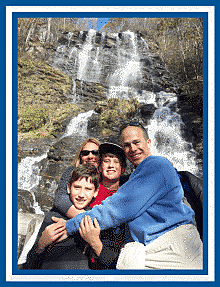 Family posing with falls behind them