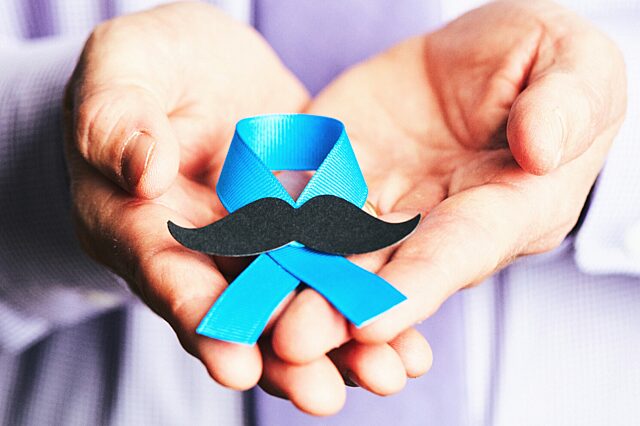 Blue ribbon with mustache in man's hands