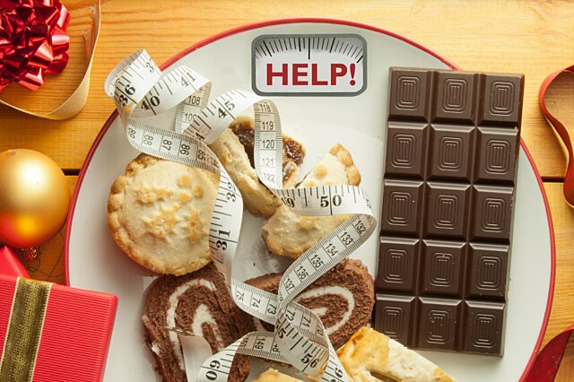 Plate with candy, pastries and a tape measure with the word help