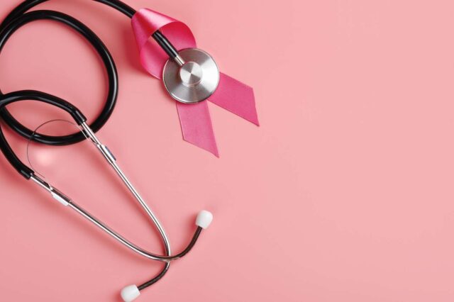 Stethoscope and pink ribbon on pink background