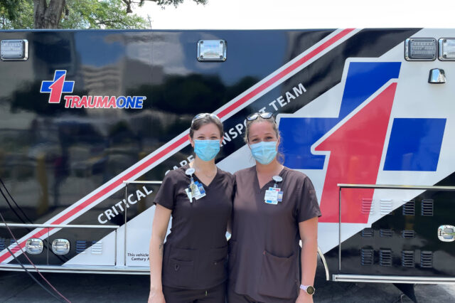 Two critical care specialists stand in front of a TraumaOne vehicle