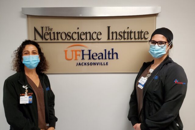 Two speech-language pathologists stand in front of sign for Neuroscience Institute UF Health