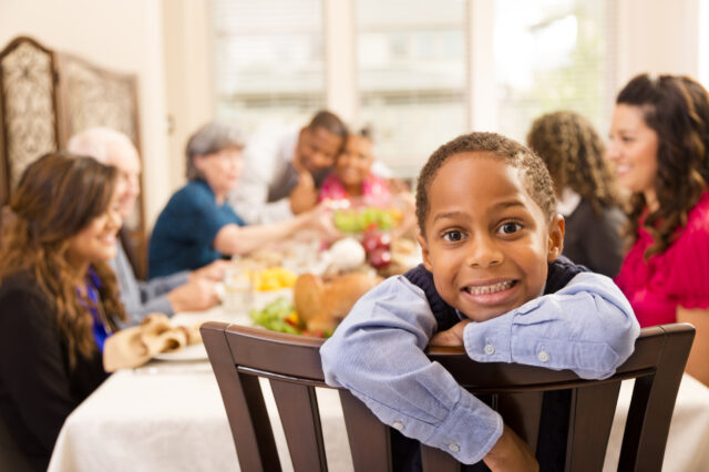 Young boy seated at family dinner table