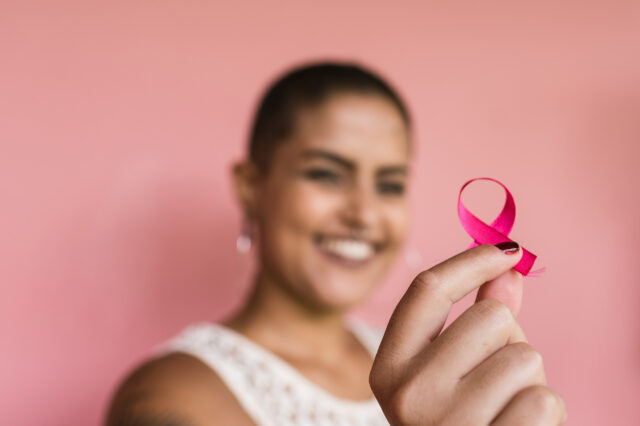 Woman holding a loop of pink ribbon