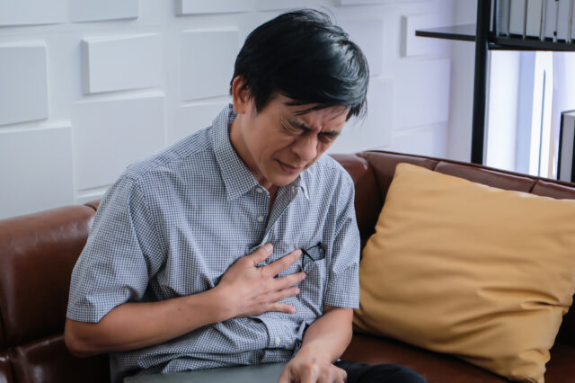 Man in pain holding his hand to his chest
