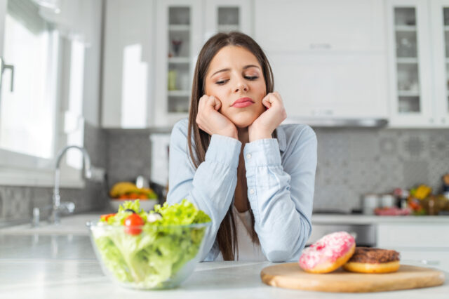 Young woman looking unhappily at a salad