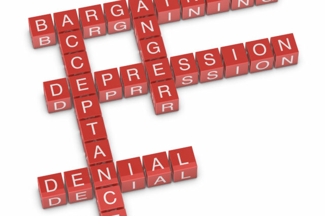 The words bargaining, anger, depression, denial, acceptance spelled out with letter blocks