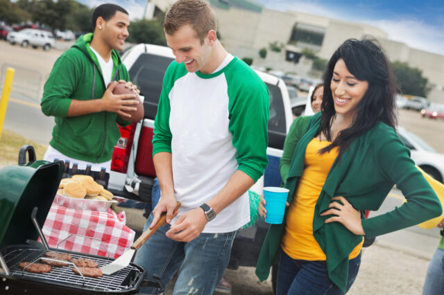 Man and woman grilling at a tailgate party