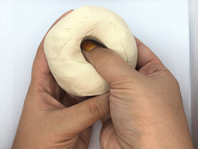 Thumb pressed into clay ball