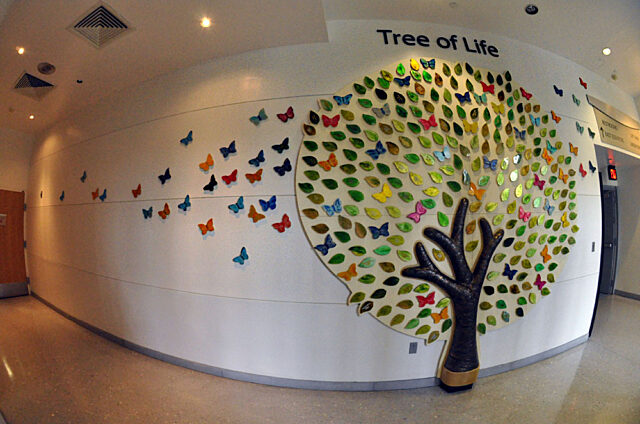 Tree of life art installation on a wall with multi-colored leaves
