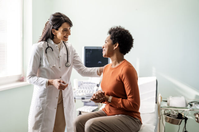 Physician talks with patient in exam room