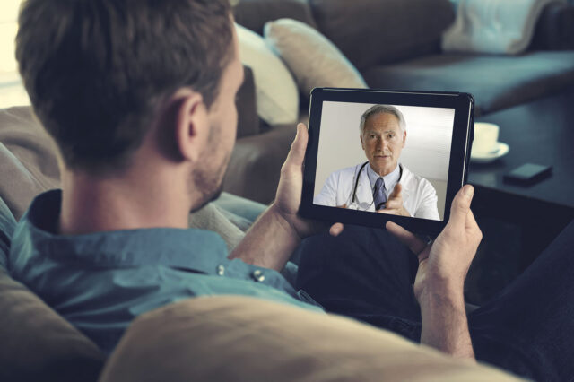 Man converses with a physician on his tablet computer